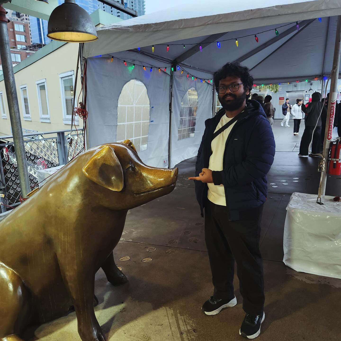 Vivek points at a sculpture of a pig